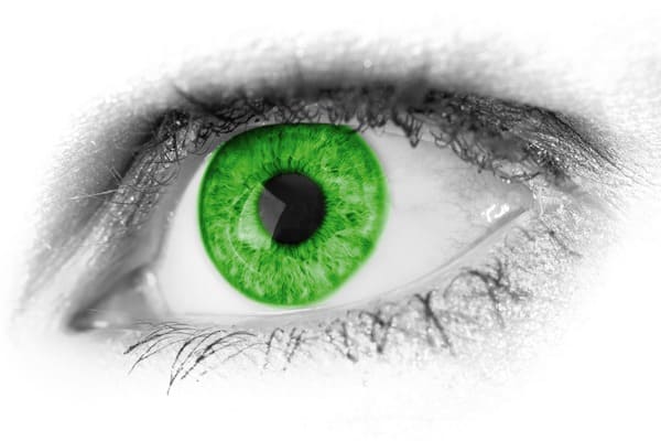 A close up of an eye with a green retina color.